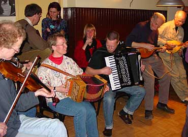 Docenten en cursisten in actie in de bar. Niet zo vol als bij het weekend Iers of Doorslaande Tongen, maar wel gezellig druk.