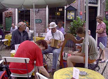 Günther, Gert-Jan en Erlinde (harp) op een terrasje.