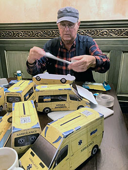 Eduard Bekker knutselt de Oekra�ense ambulances (met gleuf en QR-code) in elkaar bij de bar.