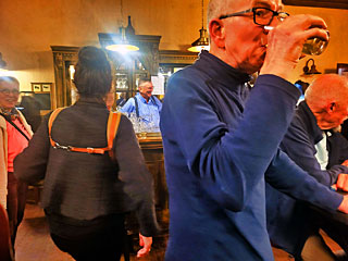 Jammen bij de bar. We zien hier de rug van Raquel Gigot, waarbij een dwarsverbindig de draagriemen van haar chromatische accordeon tot een soort tuigje maakt: vaak nood&shy;zakelijk tegen het afzakken van met name de linker schouderriem.