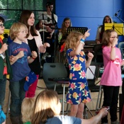 Kindermuziekgroep op de voorgrond, muziekpubers op de achtergrond.